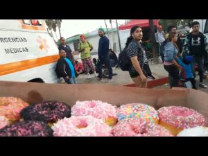 Livestreamer goes to hand out donuts to children of the caravan, instead finds almost nothing but grown men who swarm him for the donuts while the media circles the one woman and child in the area for photo opp. - conspiracy